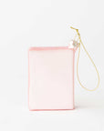 The backside of the pink passport ornament with a gold hanging loop, photographed on a clean white background.