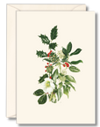 An off-white greeting card with a botanical illustration of holly leaves, white flowers, and red berries, shown with a matching off-white envelope behind it on a light gray background.