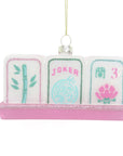 Decorative mahjong set ornament with pink base and colorful cards on a white background