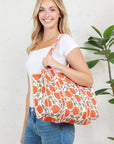Woman holding a floral-patterned bag against a white background