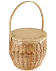 A beige picnic basket with a wicker body and a wooden lid, which has the words 'you & me. charcuterie' engraved on it.