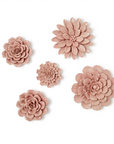A set of five pink porcelain flower wall sculptures of various sizes arranged on a plain background.