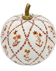 A decorative ceramic pumpkin with a white glaze, featuring a rust-orange floral and lattice pattern, and a metallic gold stem, shown on a plain white background.