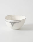 White ceramic bowl with decorative rim on a light gray background
