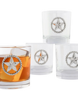 A set of four clear bar glasses, each with a unique metal Western star accent on the side, filled with a brown liquid, presumably a beverage.