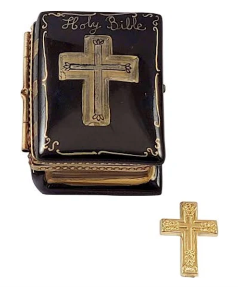 A black porcelain Bible Limoges designed to resemble a Bible with a gold cross on the lid, accompanied by a separate gold cross.