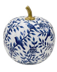 A decorative ceramic pumpkin with a white glaze, decorated with a blue floral and bird pattern, and featuring a metallic gold stem on a plain white background.