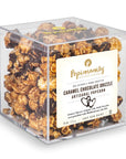 Caramel chocolate drizzle artisanal popcorn in a clear cube container with Popinsanity label.