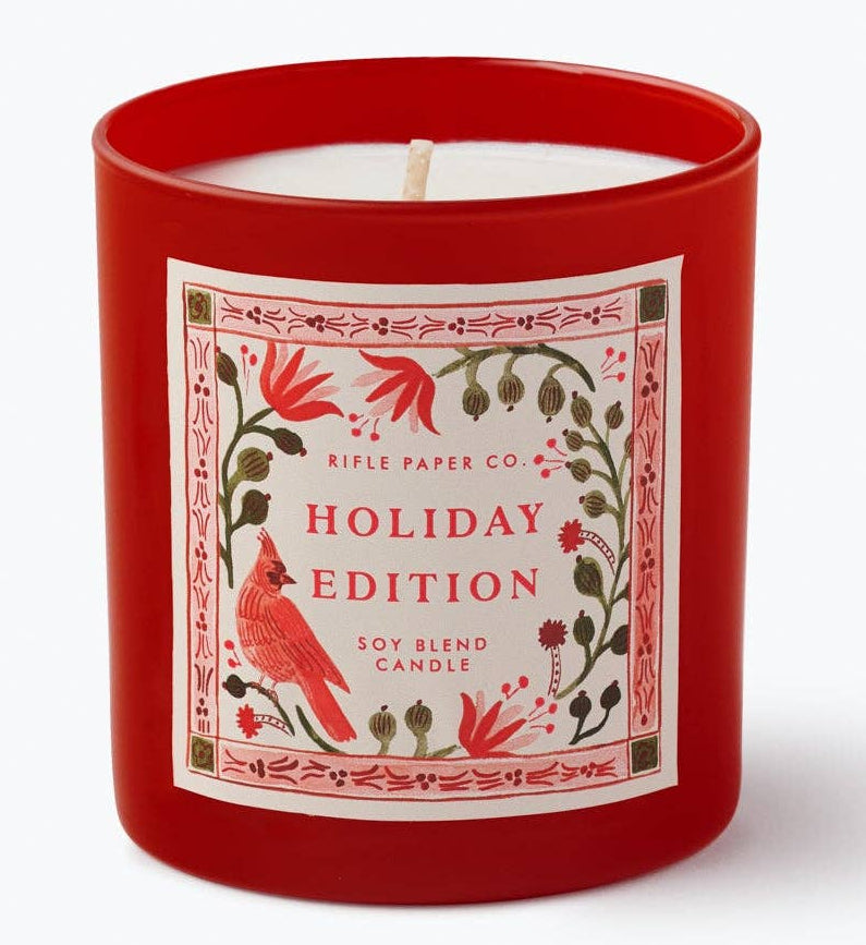 Red holiday edition candle with decorative label on a white background