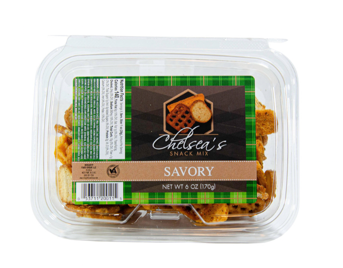 A clear plastic tub containing Chelsea's Savory Snack Mix with a green and brown label displaying the product name and an image of a cheese-flavored snack.