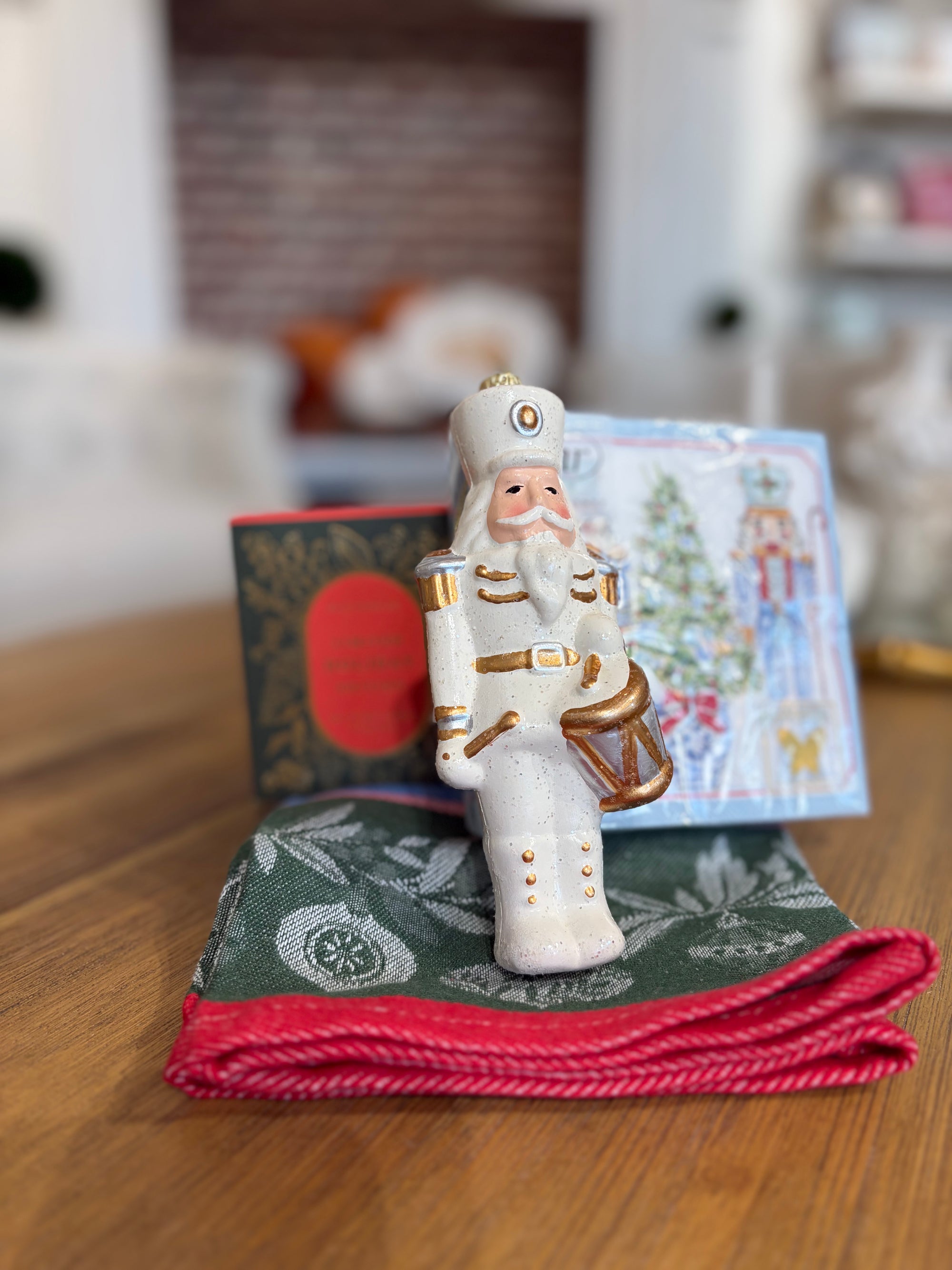 Nutcracker, cocktail napkins and candle on a Christmas towel.