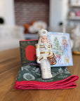 Nutcracker, cocktail napkins and candle on a Christmas towel.