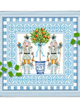 A square decorative mahjong mat featuring two nutcracker figures flanking a blue floral pot with red berries, surrounded by ornate blue patterned borders. Green mahjong tiles are scattered around the edges on a white background.