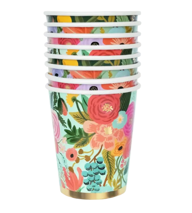 A stack of paper cups with a colorful floral print, featuring red, pink, yellow, and blue flowers with green leaves on a mint background, finished with white rims and a gold-colored base.
