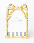 Gold picture frame with bow design on a white background