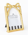 Gold picture frame with bow design on a white background