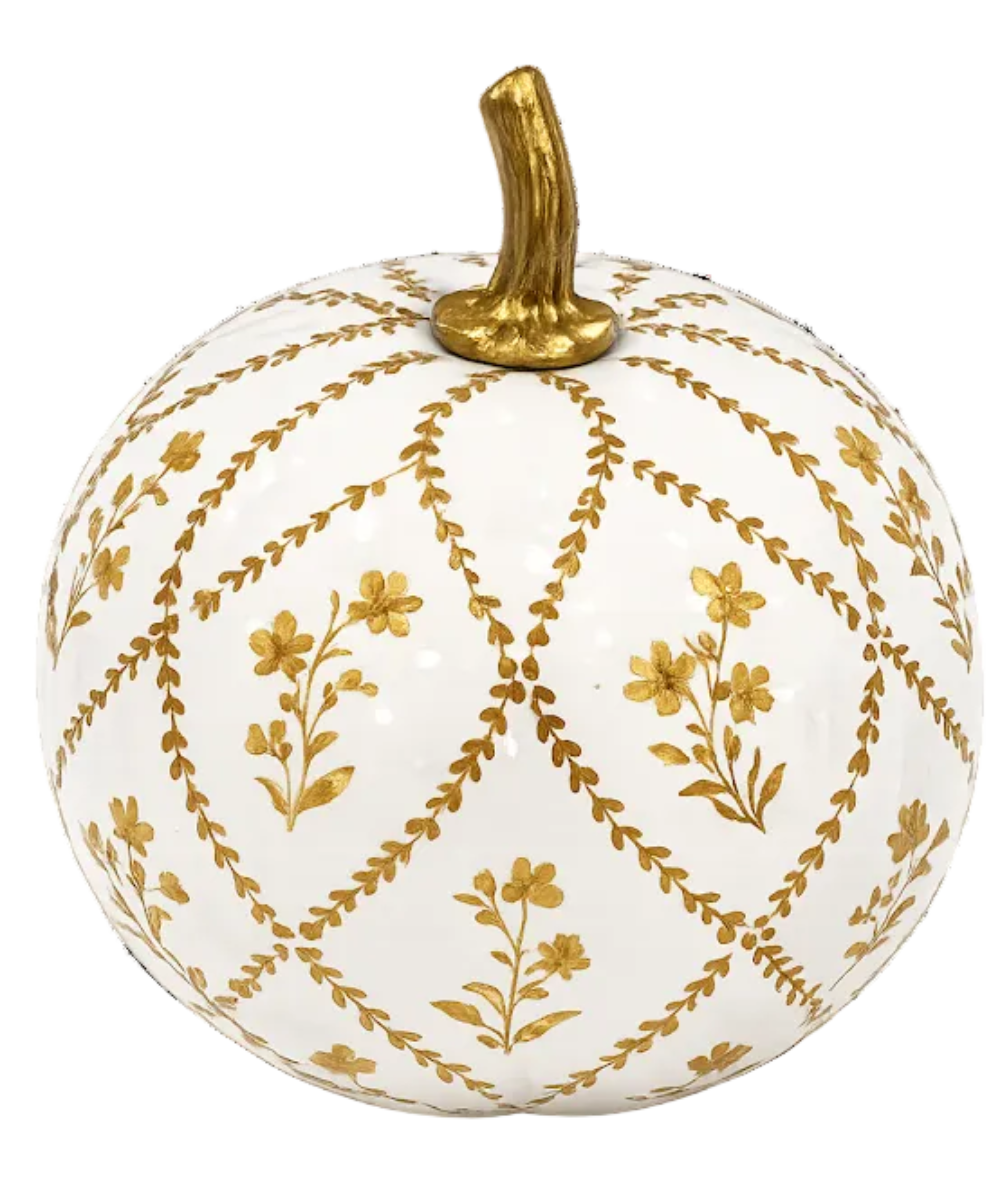 A decorative ceramic pumpkin with a glossy white glaze, decorated with a gold geometric lattice pattern and small gold floral motifs, featuring a textured gold stem on a plain white background.