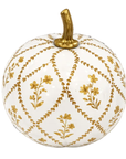 A decorative ceramic pumpkin with a glossy white glaze, decorated with a gold geometric lattice pattern and small gold floral motifs, featuring a textured gold stem on a plain white background.