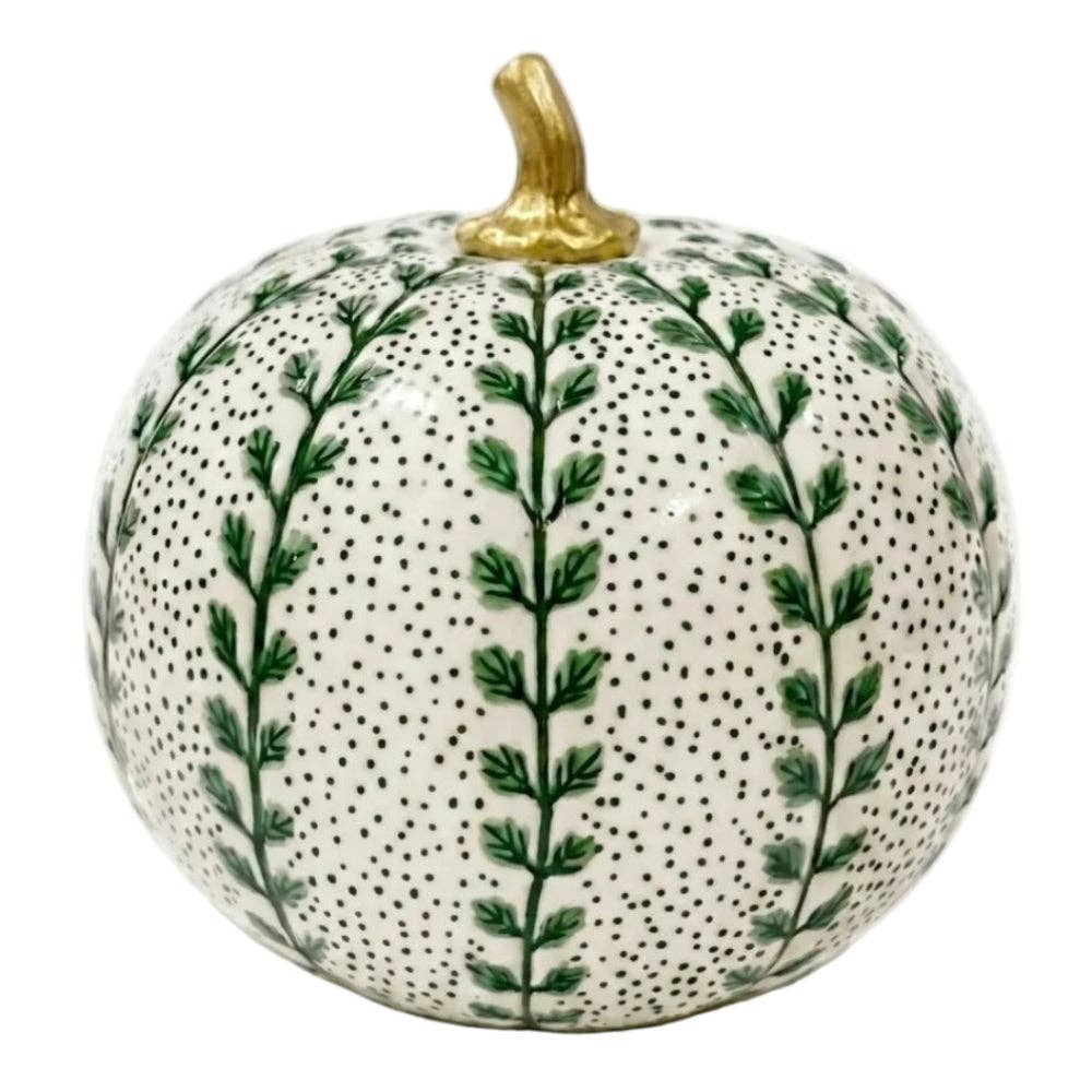 A decorative ceramic pumpkin with a white glazed base, covered in green leafy vine patterns and small black dots, featuring a metallic gold stem.