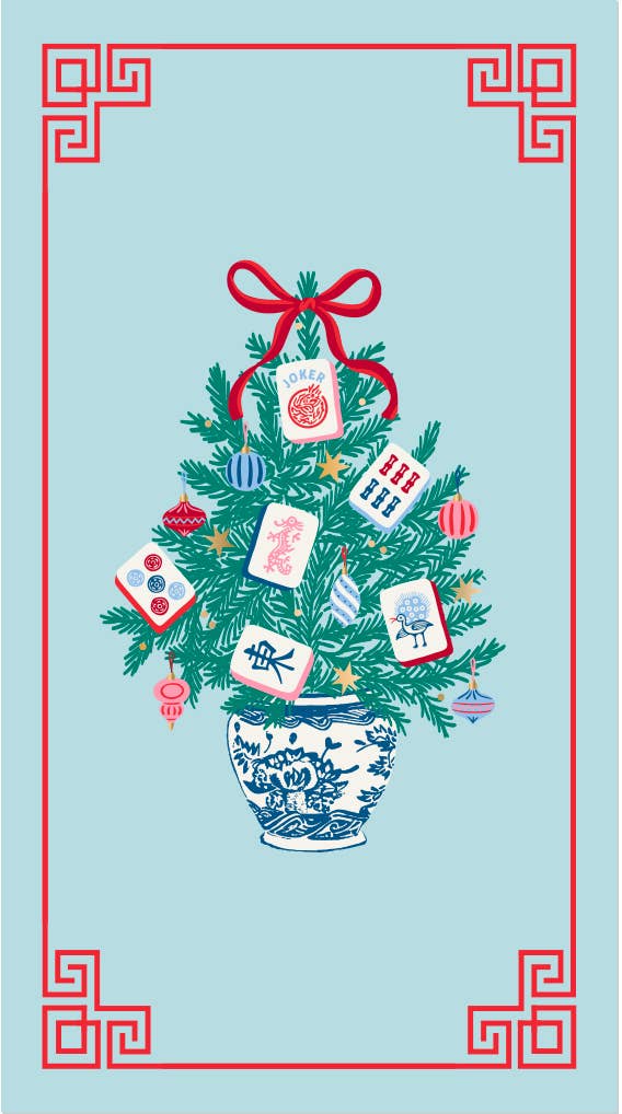 A festive illustrated tree guest towel made of green pine branches decorated with red ornaments, a red bow, and several playing card ornaments, set in a blue-and-white patterned pot on a light blue background with a red decorative border.