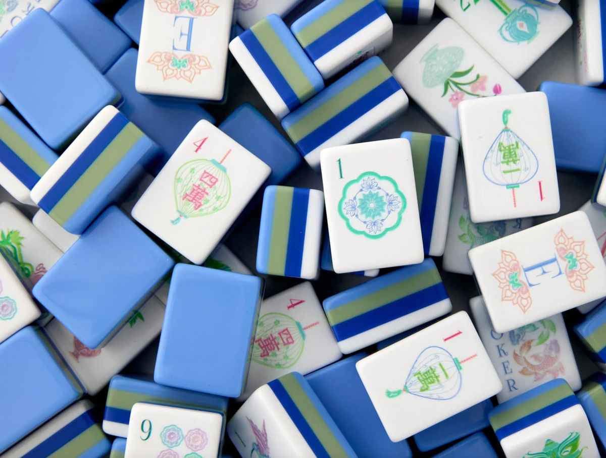 Close-up of a pile of blue and white Mahjong tiles.