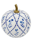 A decorative ceramic pumpkin with a white glaze, decorated with a blue floral and lattice pattern, and featuring a textured gold stem.