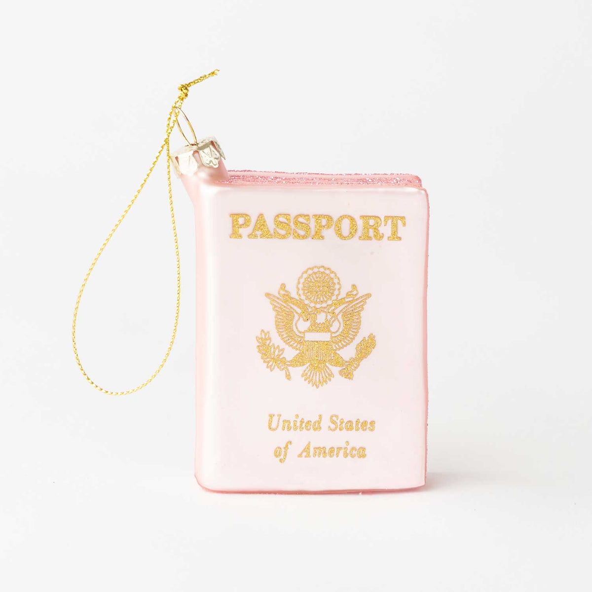 A novelty Christmas ornament shaped like a pink passport with gold foil-style lettering and emblem, complete with a gold hanging string, shown on a plain white background.