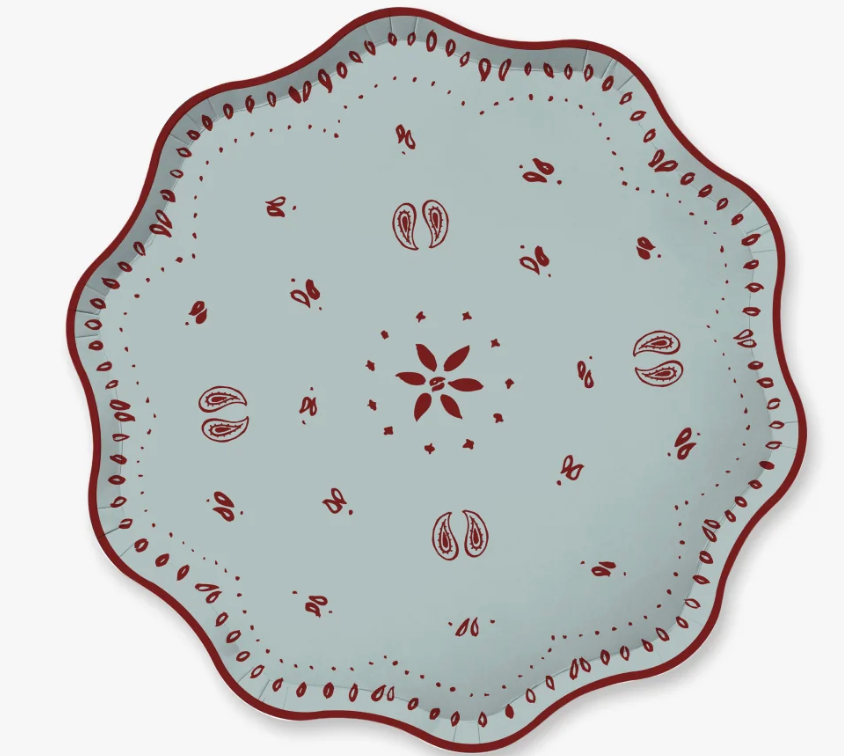 A scalloped paper plate with a light blue-gray and a dark red hand-painted folk pattern, shown from a top-down view on a white background.