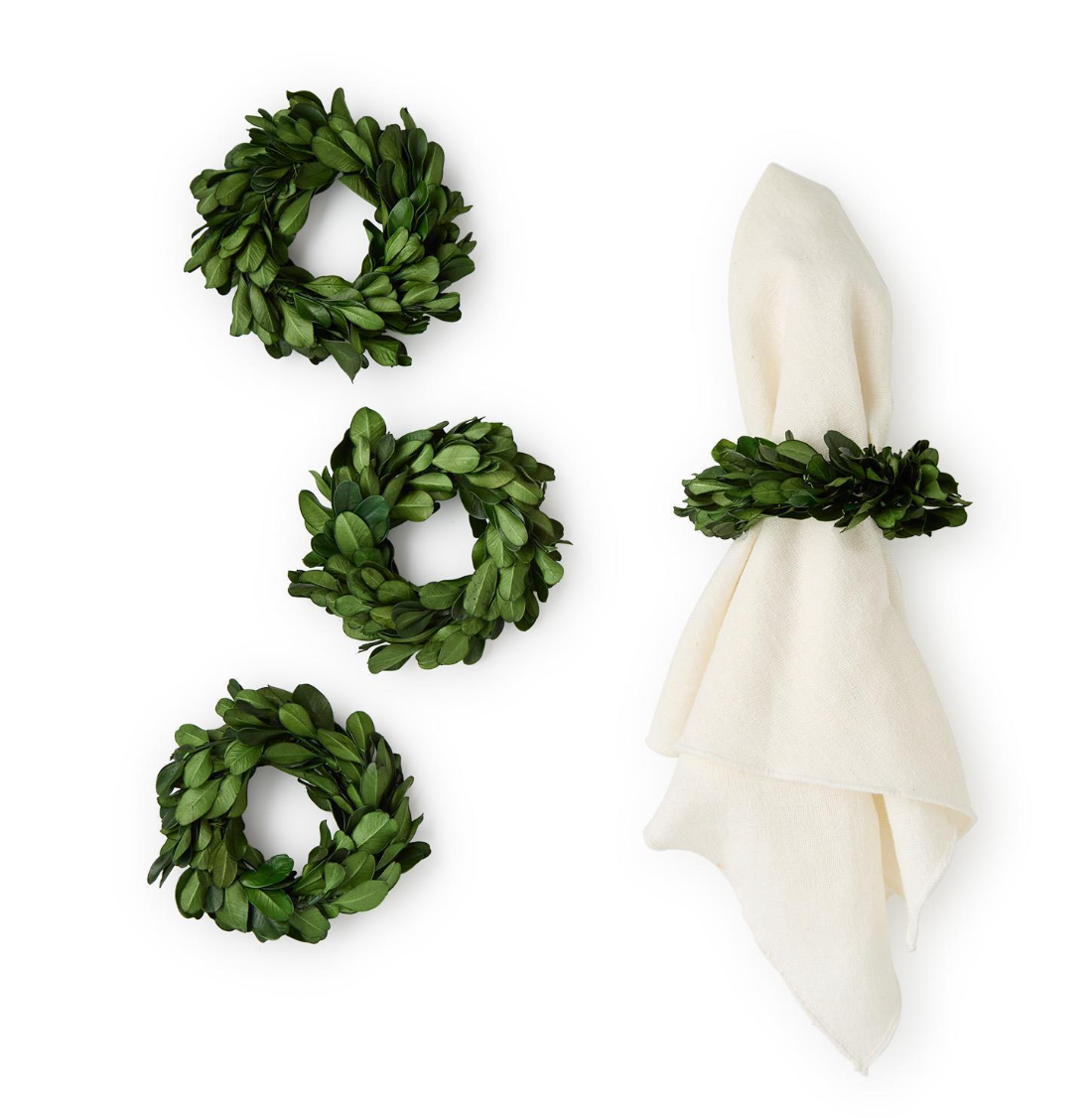 Set of four green leaf wreaths with a white napkin on a white background