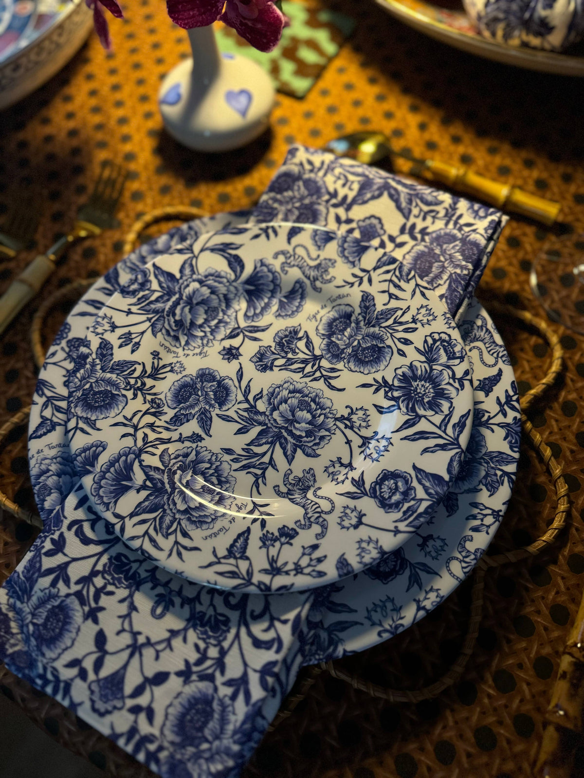 A set of four melamine salad/dessert plates with a blue floral pattern on a wooden table.