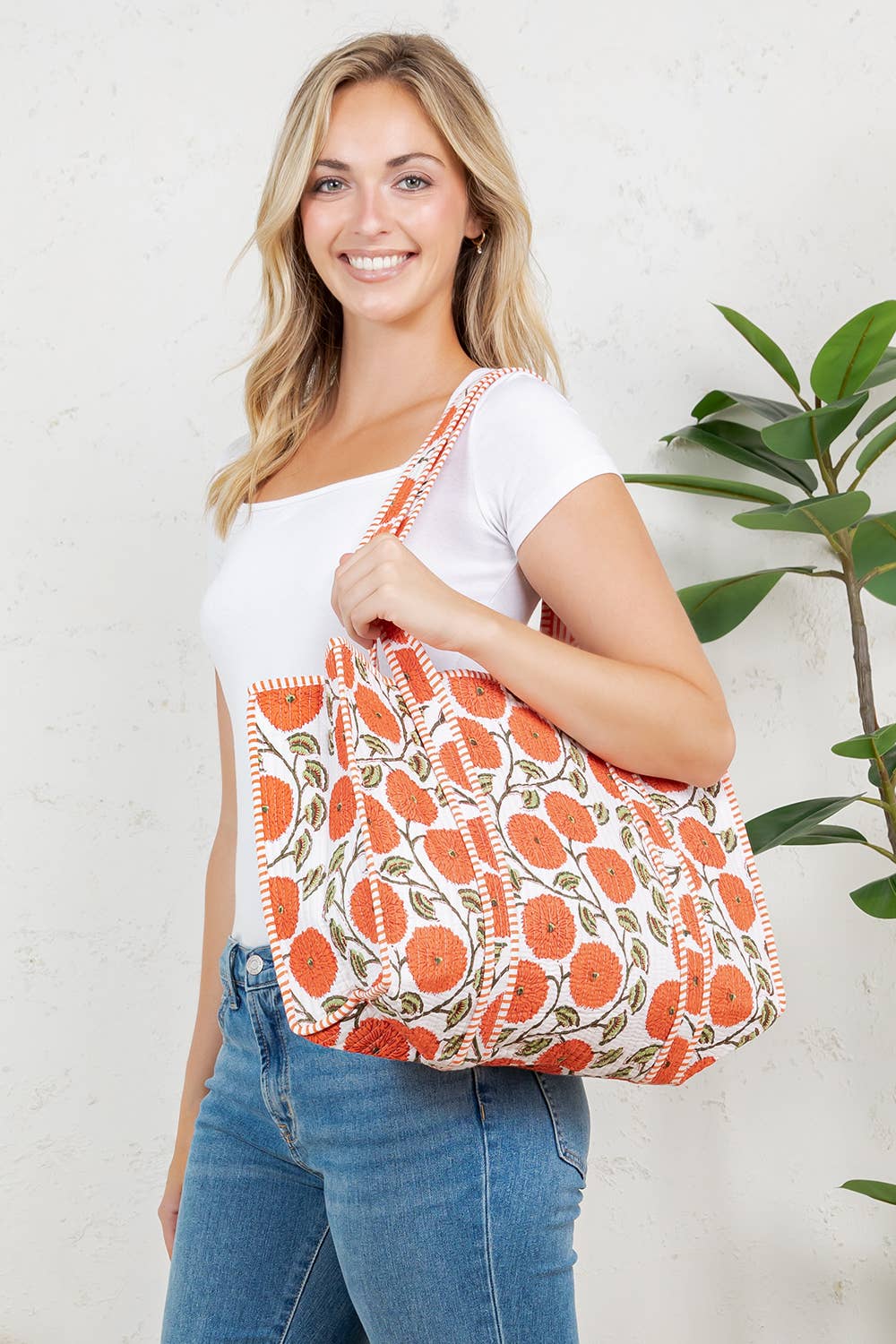 Woman holding a floral-patterned bag against a white background